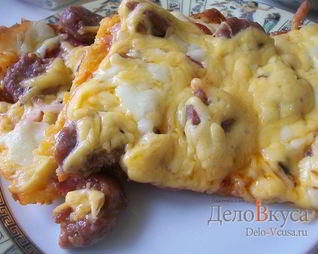 Пицца с домашними колбасками, салями, беконом, моцареллой, твердым сыром и зеленью на тонкой основе