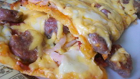 пицца с домашними колбасками, салями, беконом, моцареллой, твердым сыром и зеленью на тонкой основе